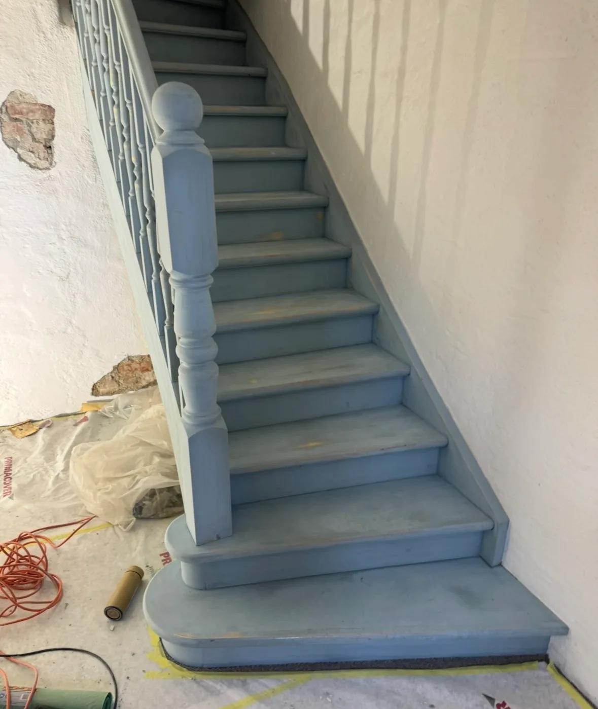 Newly painted blue interior staircase with bannister