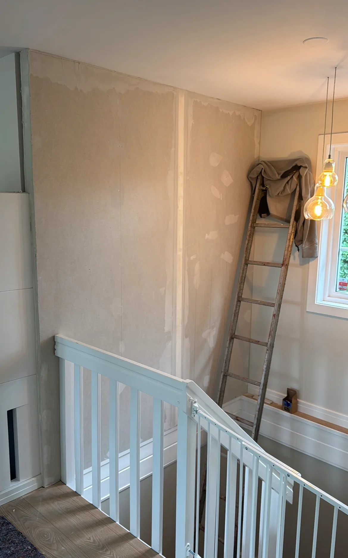 Interior renovation with primed walls and protective barriers