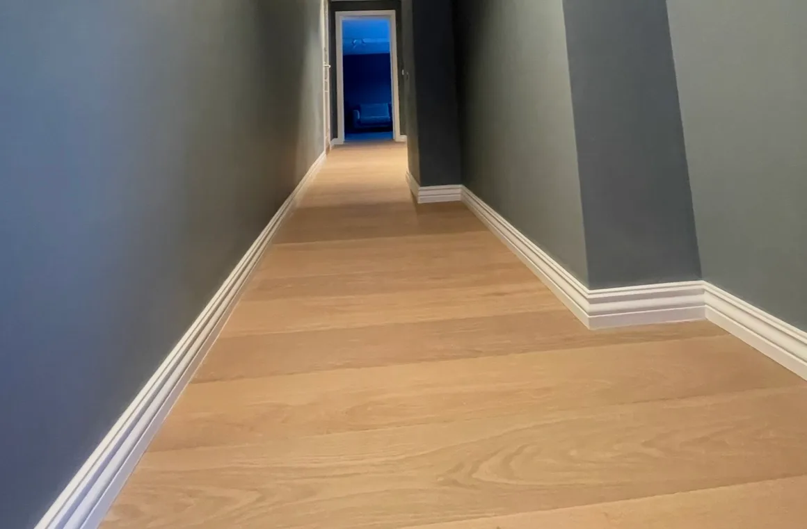 Modern hallway renovation with warm wood flooring