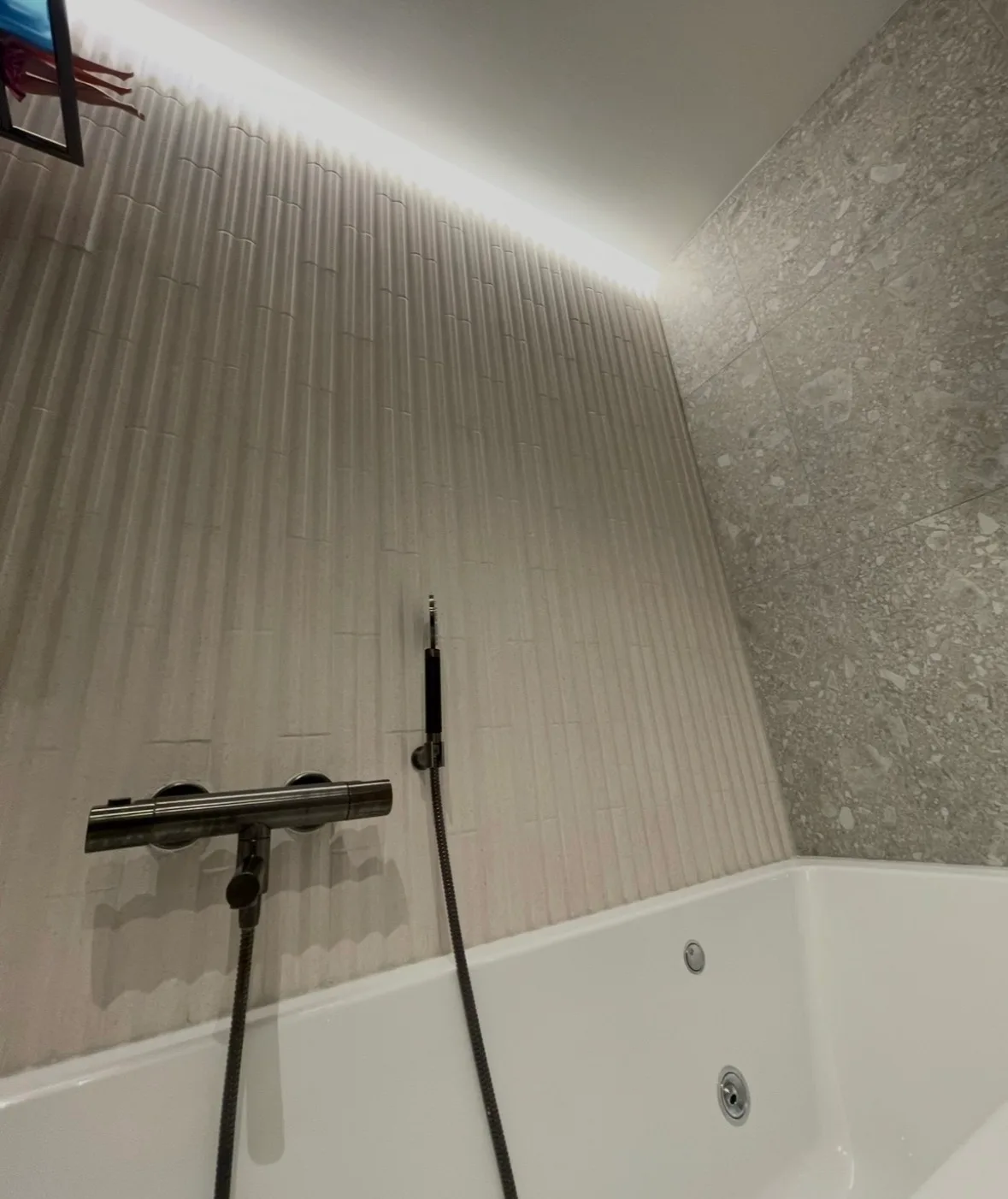 Moderne baderomsinnredning med fliser på veggene og downlights i taket