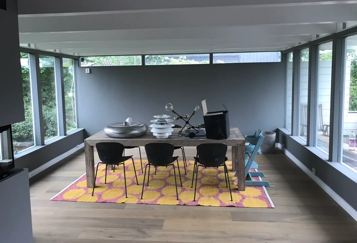 Lys og moderne spisestue med et stort bord og stoler